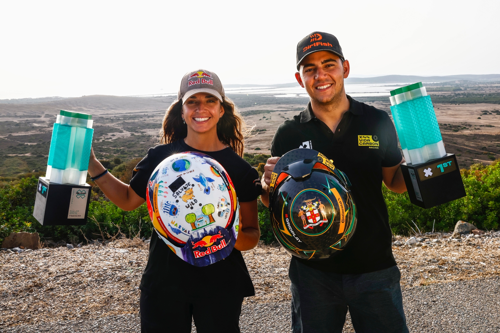 CAPO TEULADA, SARDINIA, ITALY - SEPTEMBER 17: Cristina Gutierrez (ESP), X44 Vida Carbon Racing, and Fraser McConnell (JAM), X44 Vida Carbon Racing, with their trophies and helmets during the Island X-Prix II on September 17, 2023 in Capo Teulada, Sardinia, Italy. (Photo by Sam Bloxham / LAT Images)