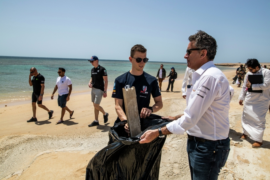 MARCH 31: Timmy Hansen (SWE), Andretti United Extreme E, puts rubbish into a sack held open by Alejandro Agag, CEO, Extreme E during the Saudi Arabia on March 31, 2021. (Photo by Sam Bloxham / LAT Images)